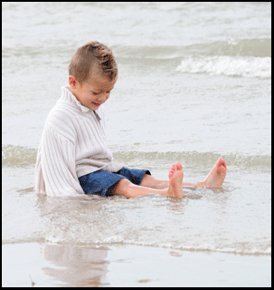 boy playing in the water of Lake Erie,  Condos, Port Dover on the Gold Coast south coast of Ontario